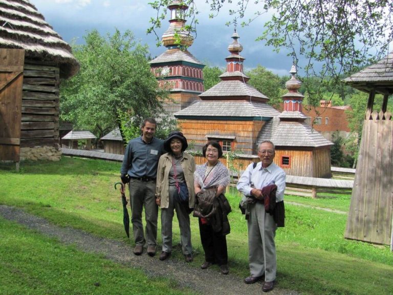 Small private tour group in front of the wooden church in Bardejov Spa