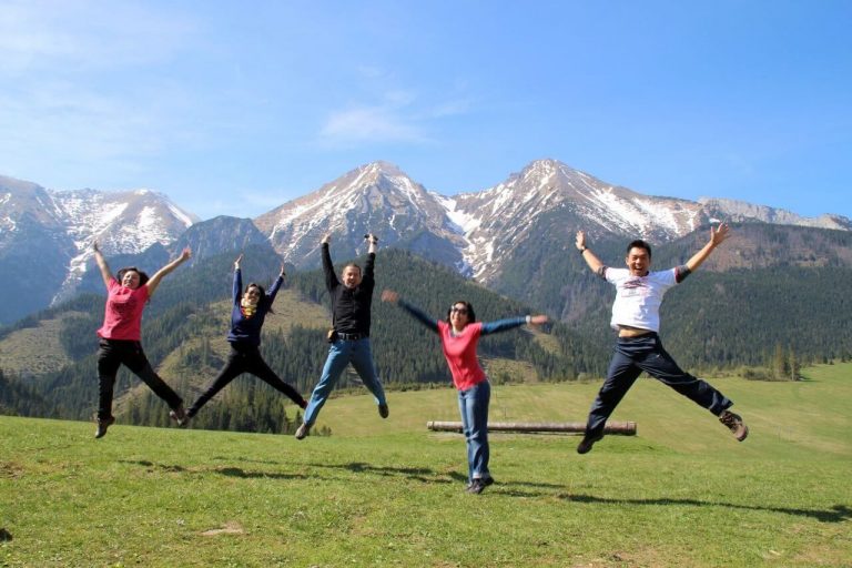 Happy travellers jumping up with Tatra mountains in the background